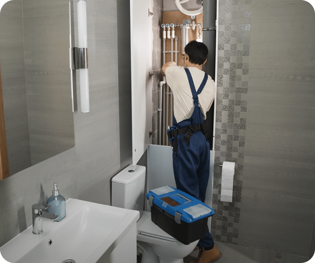 A plumber at work in a bathroom